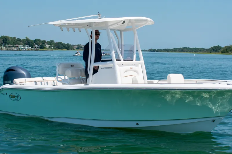 The Image of 2022 Sea Hunt Ultra 219 boat cruising on a sunny day in clear blue waters. - 0