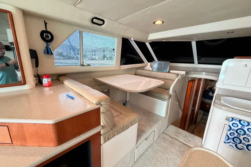 Slide: The Image of Interior of 1997 Sea Ray 550 Sedan Bridge yacht with dining area and seating. - 26