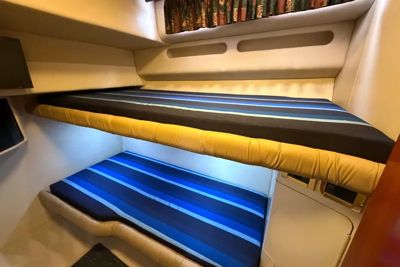 Slide: The Image of Bunk beds with striped bedding in 1997 Sea Ray 550 Sedan Bridge yacht cabin. - 31