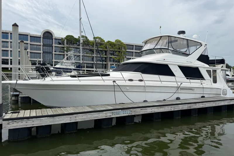 Slide: The Image of 1997 Sea Ray 550 Sedan Bridge yacht docked at marina, overcast sky. - 5