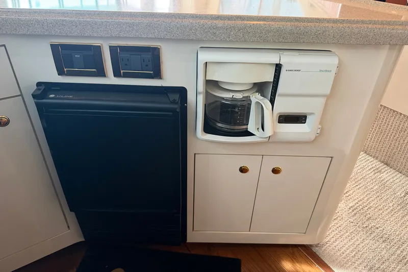 Slide: The Image of 1997 Sea Ray 550 Sedan Bridge galley with coffee maker and mini fridge. - 28