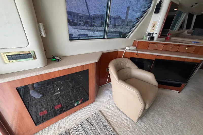 Slide: The Image of Interior of 1997 Sea Ray 550 Sedan Bridge yacht with beige chair and wooden cabinetry. - 23