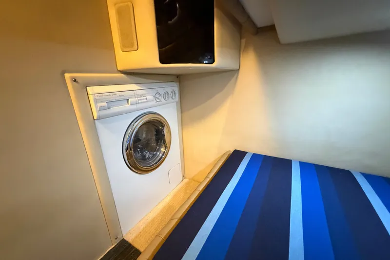 Slide: The Image of Laundry area in 1997 Sea Ray 550 Sedan Bridge yacht with striped bedding. - 32