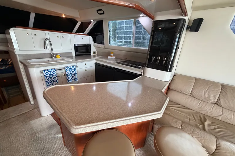Slide: The Image of Luxurious 1997 Sea Ray 550 Sedan Bridge yacht interior with modern kitchen and seating area. - 25