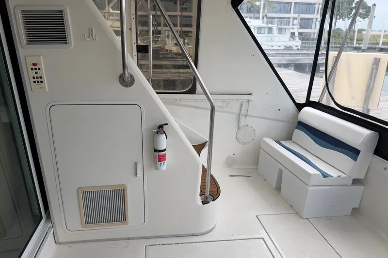 Slide: The Image of 1997 Sea Ray 550 Sedan Bridge interior with seating, stairs, and fire extinguisher. - 6