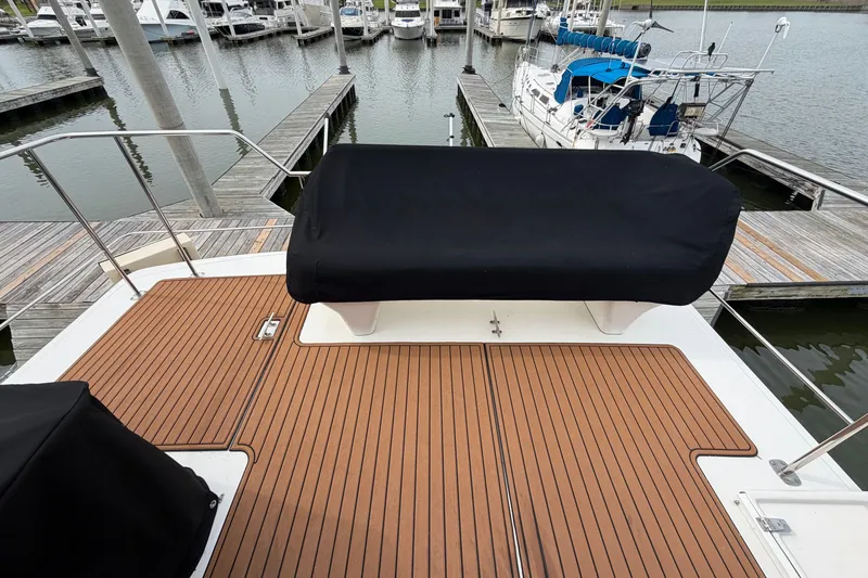 Slide: The Image of 1997 Sea Ray 550 Sedan Bridge yacht deck with covered seating at marina. - 14