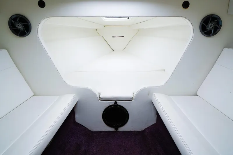 Slide: The Image of Interior cabin of a 2000 Active Thunder 32 boat, featuring white seating and speakers. - 14
