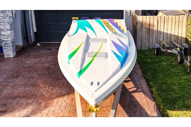 Slide: The Image of 2000 Active Thunder 32 speedboat with colorful graphics on a driveway. - 24