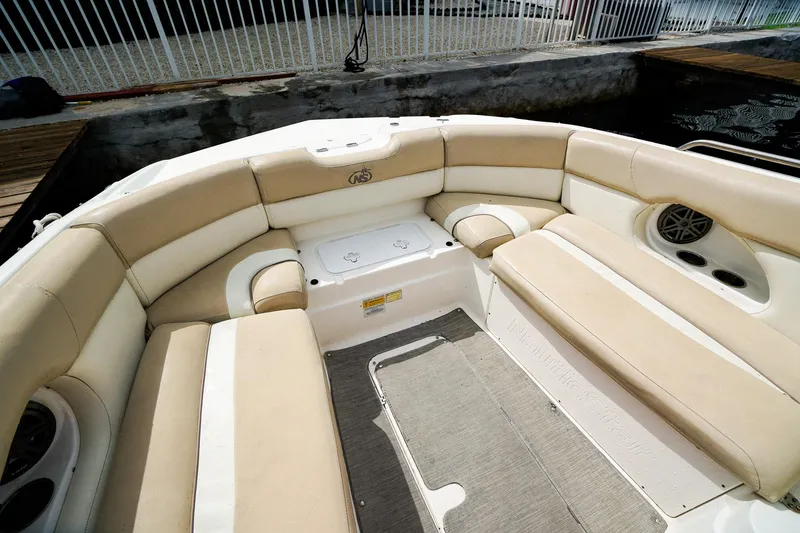 Slide: The Image of 2017 NauticStar 243DC Sport Deck boat interior with beige seating and speaker system. - 18