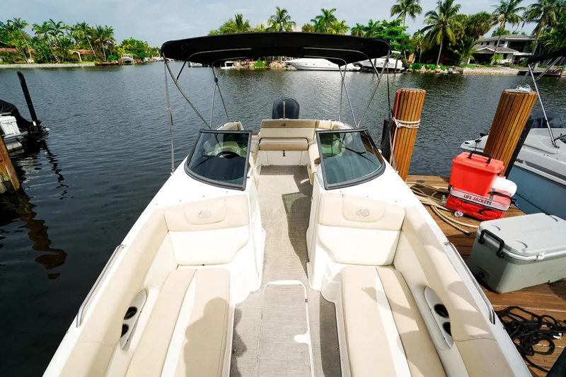 Slide: The Image of 2017 NauticStar 243DC Sport Deck boat docked by a scenic waterfront. - 19