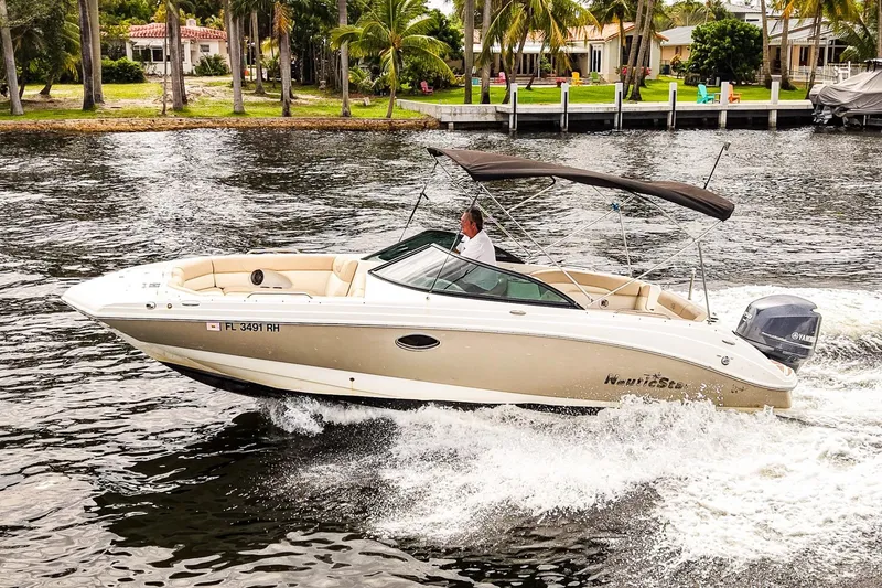 The Image of 2017 NauticStar 243DC Sport Deck boat cruising on a scenic waterway. - 0