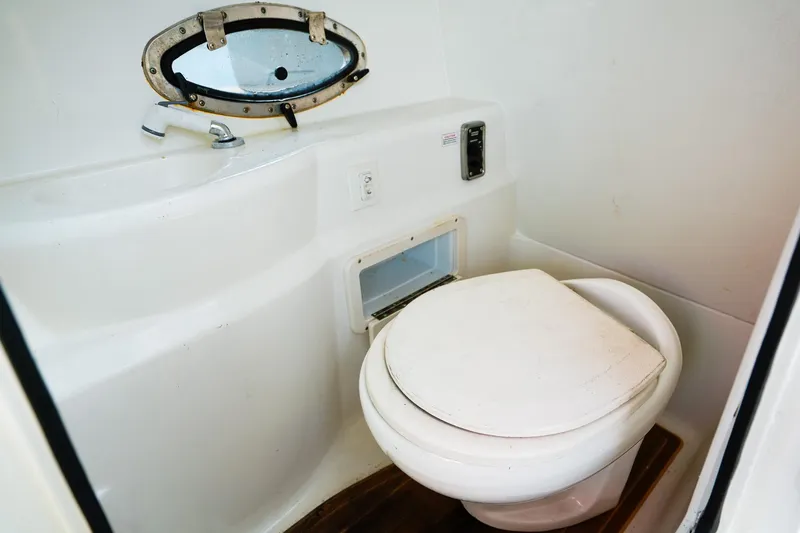 Slide: The Image of 2017 NauticStar 243DC Sport Deck boat bathroom with toilet and sink. - 16
