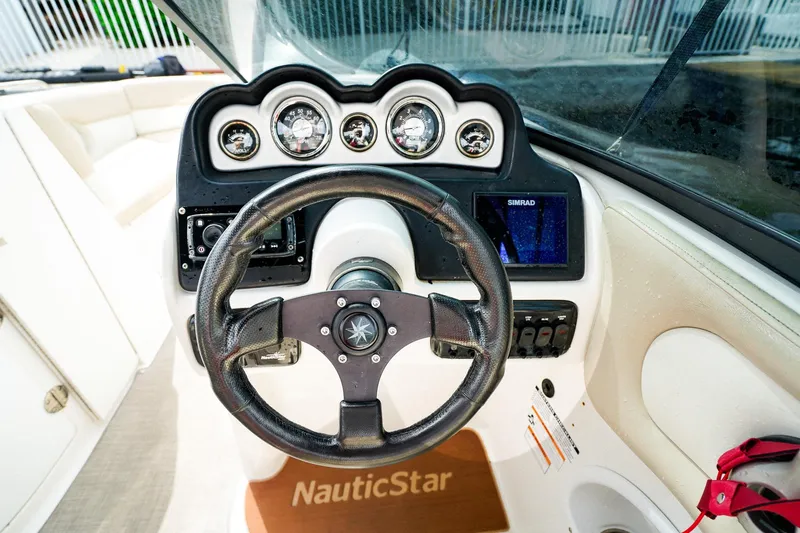 Slide: The Image of 2017 NauticStar 243DC Sport Deck dashboard with steering wheel and gauges. - 14