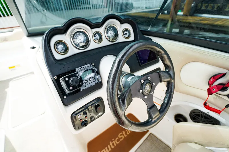 Slide: The Image of 2017 NauticStar 243DC Sport Deck dashboard with steering wheel and gauges. - 13