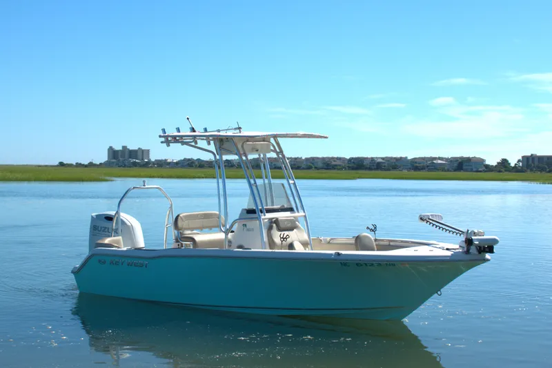Slide: The Image of 2024 Key West 203 FS boat on calm water, clear sky background. - 2