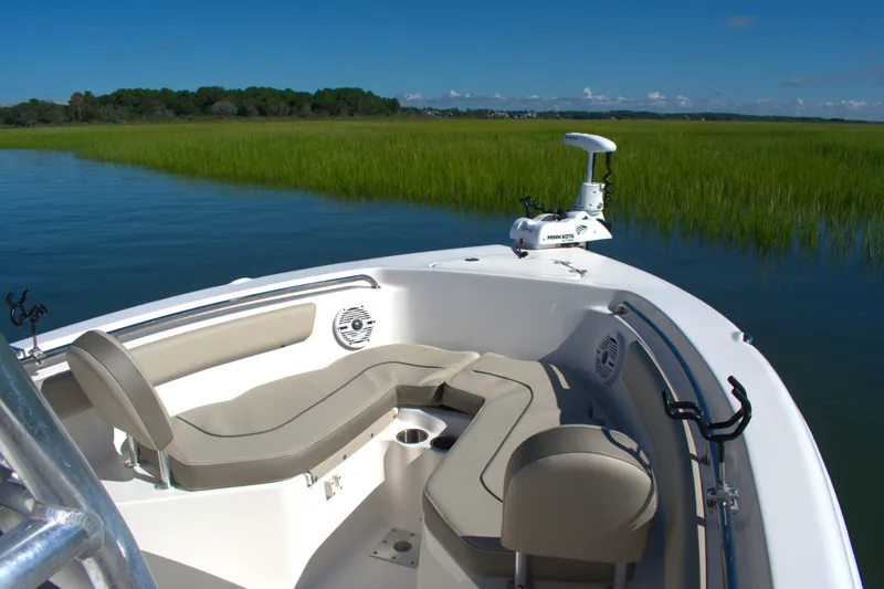 Slide: The Image of 2024 Key West 203 FS boat interior with seating, on calm water near grassy shoreline. - 6