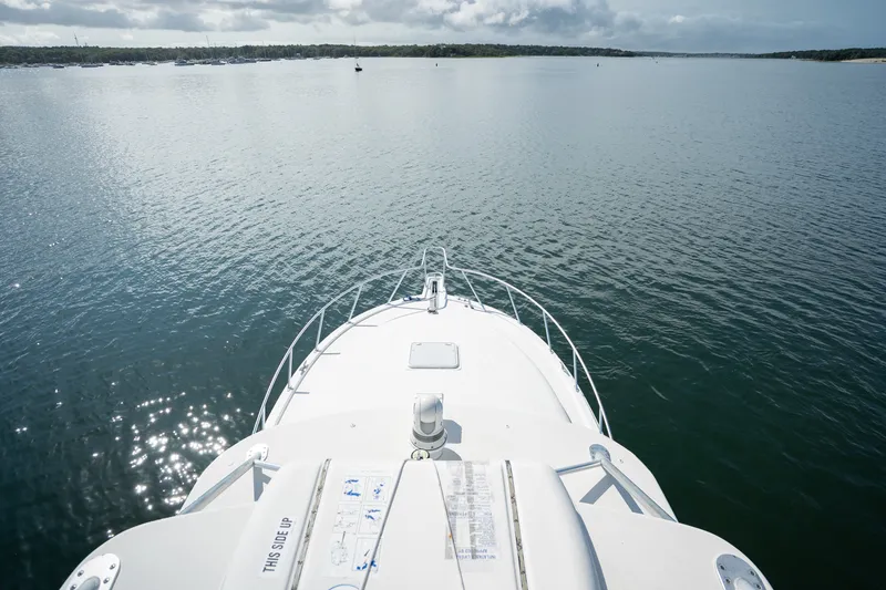 Slide: The Image of Bow view of 2011 Cabo 36 Express yacht on calm waters under cloudy sky. - 19