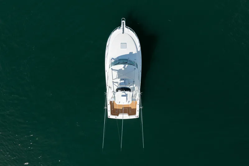 Slide: The Image of Overhead view of a 2011 Cabo 36 Express boat on dark water. - 15