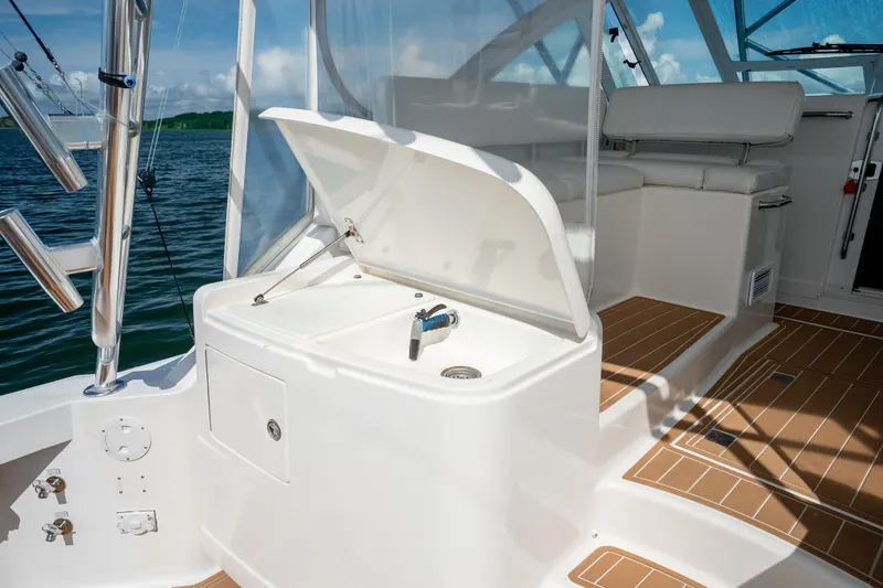 Slide: The Image of 2011 Cabo 36 Express yacht interior with open storage compartment and seating area. - 28