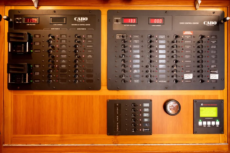 Slide: The Image of Electrical control panel on a 2011 Cabo 36 Express yacht, featuring various switches and gauges. - 43