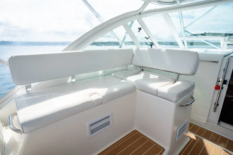 Slide: The Image of Interior seating of 2011 Cabo 36 Express yacht with white upholstery and wooden flooring. - 36