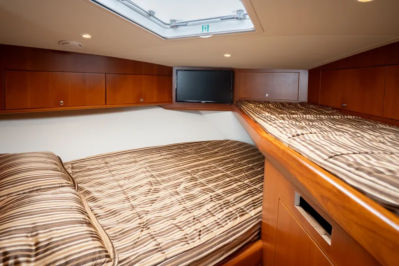 Slide: The Image of Luxurious cabin interior of 2011 Cabo 36 Express yacht with striped bedding. - 38