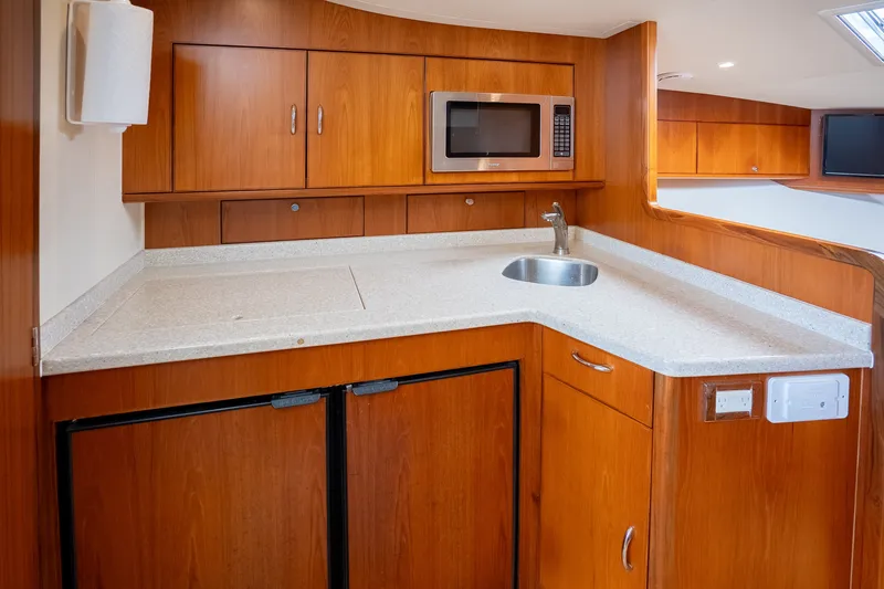 Slide: The Image of 2011 Cabo 36 Express yacht kitchen with wood cabinetry, sink, and microwave. - 41