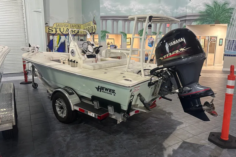 Slide: The Image of 2024 Hewes Redfisher 16 boat with Yamaha engine on display indoors. - 3