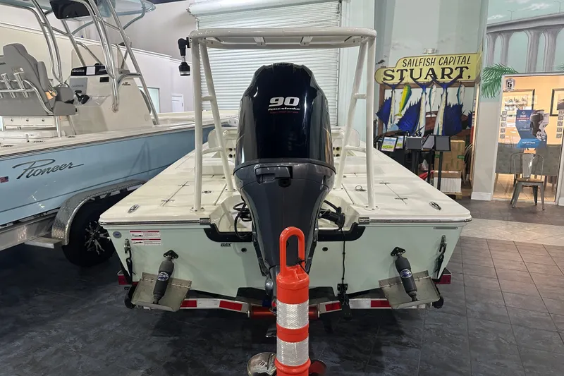 Slide: The Image of 2024 Hewes Redfisher 16 boat with 90 horsepower engine displayed indoors. - 4