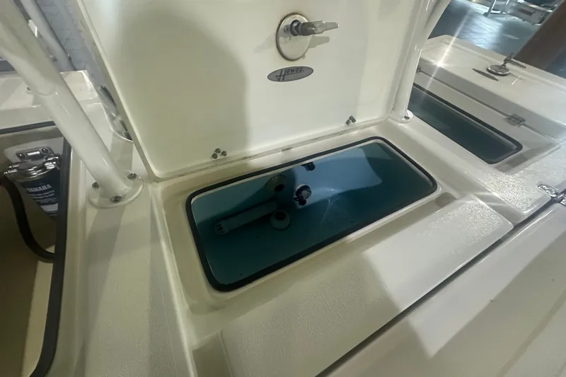 Slide: The Image of 2024 Hewes Redfisher 16 boat storage compartment with open lid and visible interior. - 11