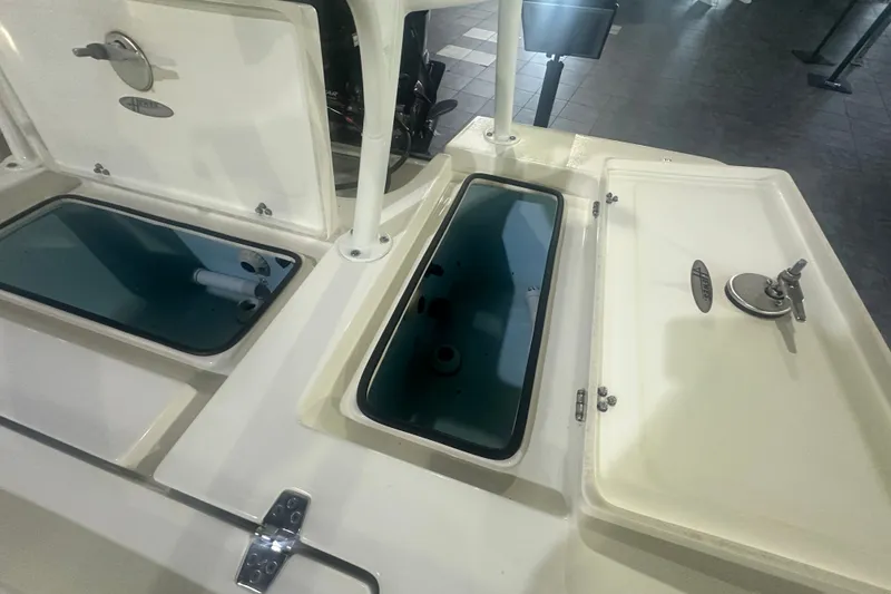 Slide: The Image of 2024 Hewes Redfisher 16 boat storage compartments with open lids, showcasing interior design. - 12