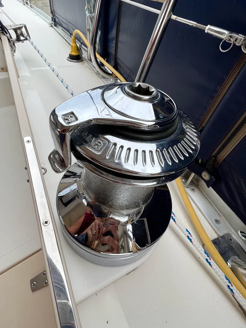Slide: The Image of Nahaufnahme einer glänzenden Winde auf einem Segelboot, umgeben von Seilen und Metallgeländern. - 51