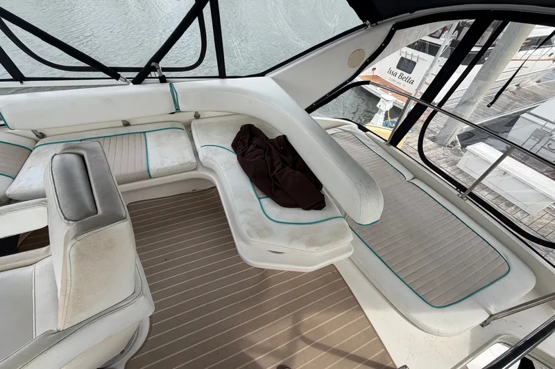 Slide: The Image of 1997 Sea Ray 400 Sedan Bridge interior with white seating and brown cover. - 13