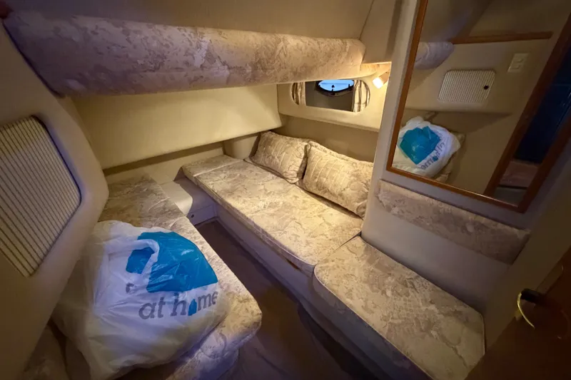 Slide: The Image of 1997 Sea Ray 400 Sedan Bridge cabin interior with beige upholstery and storage bags. - 20