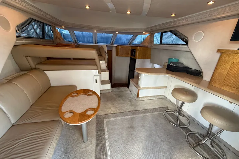 Slide: The Image of Luxurious interior of a 1997 Sea Ray 400 Sedan Bridge yacht with modern seating and bar area. - 10