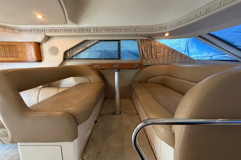 Slide: The Image of Interior of 1997 Sea Ray 400 Sedan Bridge with beige seating and wooden accents. - 18