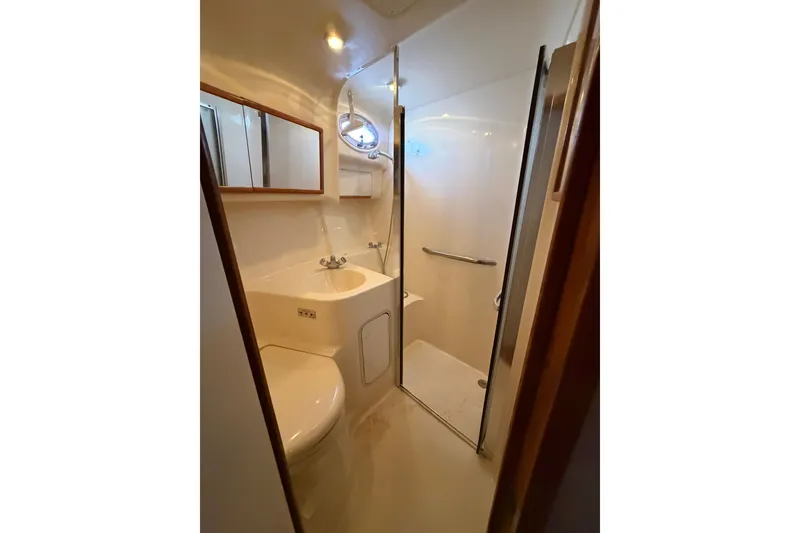 Slide: The Image of Bathroom interior of 1997 Sea Ray 400 Sedan Bridge yacht, featuring shower and sink. - 25