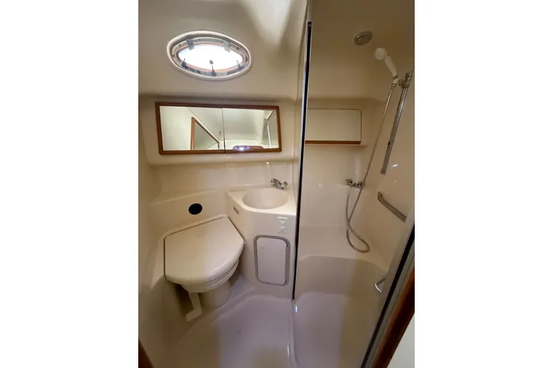 Slide: The Image of Bathroom interior of 1997 Sea Ray 400 Sedan Bridge yacht, featuring shower and toilet. - 21