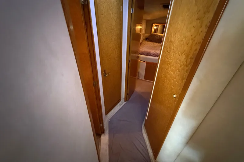 Slide: The Image of Interior hallway of a 1997 Sea Ray 400 Sedan Bridge yacht, featuring wooden doors. - 19
