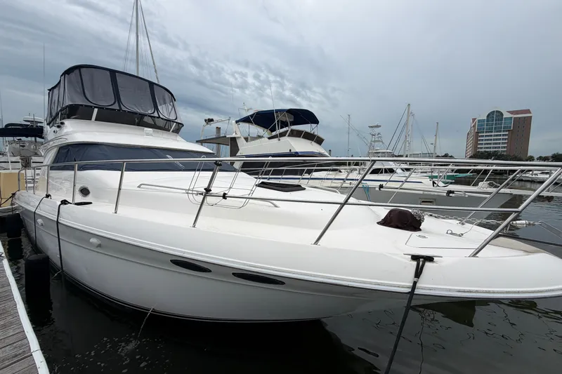 Slide: The Image of 1997 Sea Ray 400 Sedan Bridge yacht docked at marina under cloudy sky. - 3
