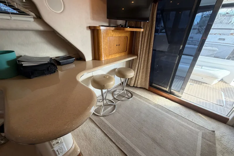 Slide: The Image of Interior of 1997 Sea Ray 400 Sedan Bridge with bar stools and sliding glass door. - 15