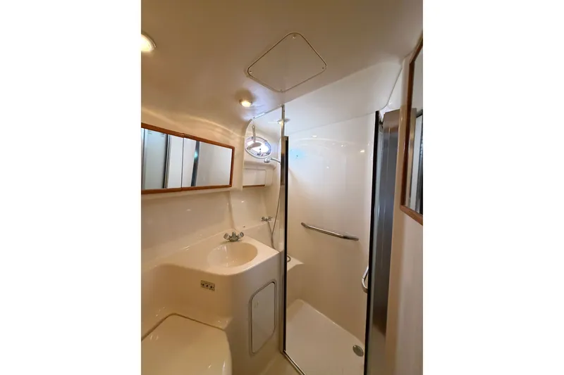 Slide: The Image of Bathroom interior of 1997 Sea Ray 400 Sedan Bridge yacht, featuring shower and sink. - 10