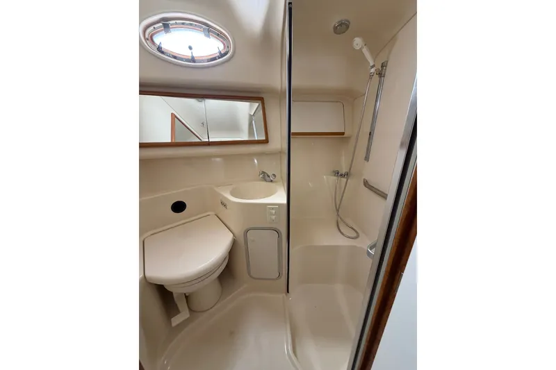 Slide: The Image of Bathroom interior of 1997 Sea Ray 400 Sedan Bridge yacht, featuring shower and toilet. - 8