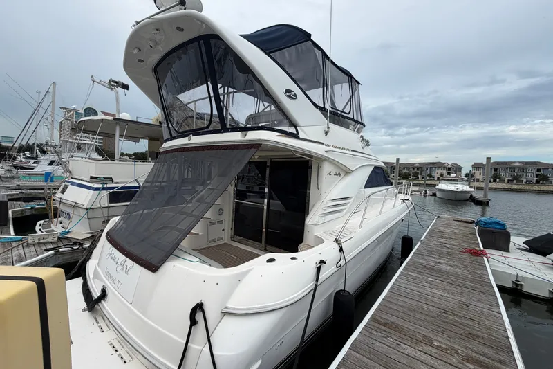 Slide: The Image of 1997 Sea Ray 400 Sedan Bridge yacht docked at marina, showcasing sleek design and spacious deck. - 2