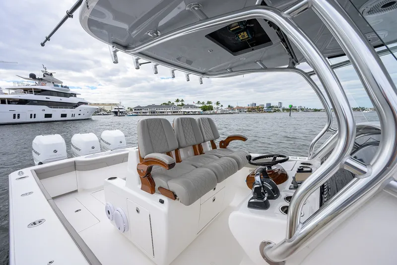 Slide: The Image of 2022 Valhalla V-37 boat interior with luxurious seating and controls, docked near yachts. - 42
