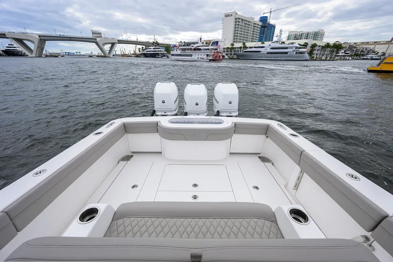 Slide: The Image of 2022 Valhalla V-37 boat with triple engines, docked near a bridge and waterfront buildings. - 19
