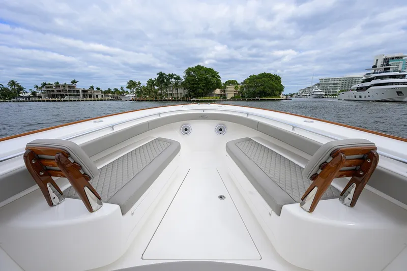 Slide: The Image of 2022 Valhalla V-37 boat interior with elegant seating, docked near luxury yachts and waterfront homes. - 47