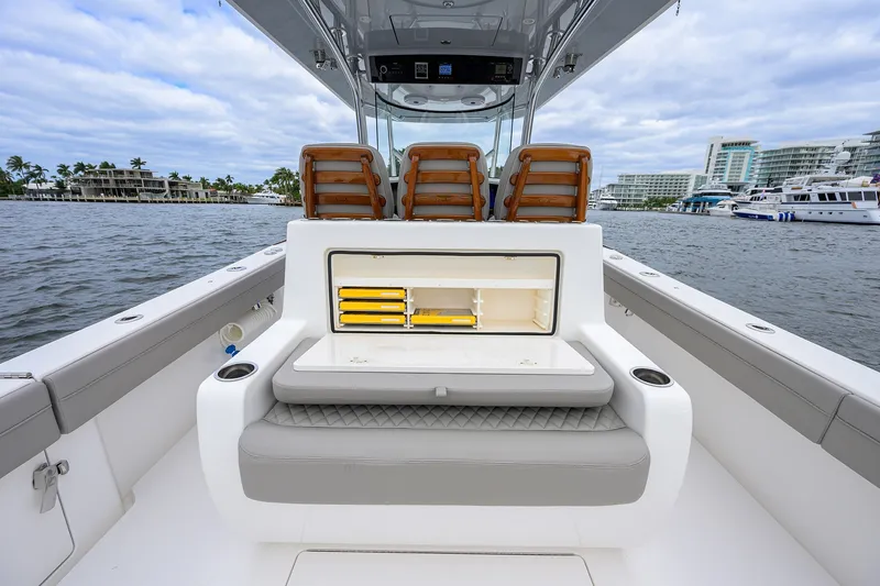 Slide: The Image of 2022 Valhalla V-37 boat interior with seating and storage, docked near waterfront buildings. - 31