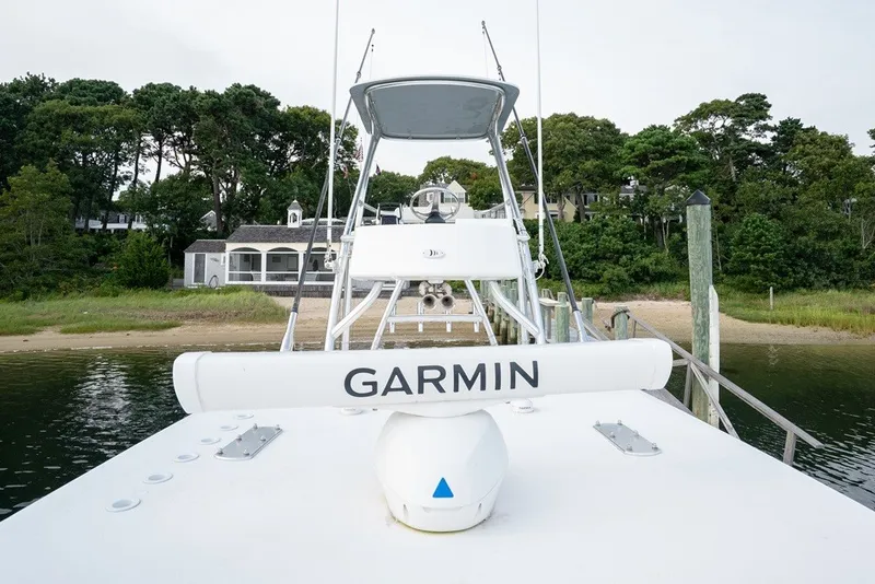 Slide: The Image of 2023 Invincible 39 Open Fisherman boat docked with Garmin equipment, surrounded by lush greenery. - 20