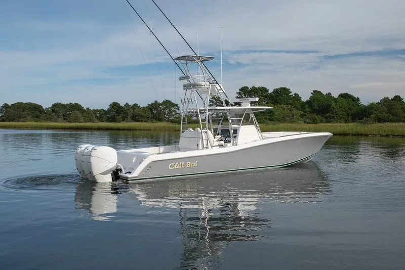 The Image of 2023 Invincible 39 Open Fisherman boat on calm water, surrounded by greenery. - 4